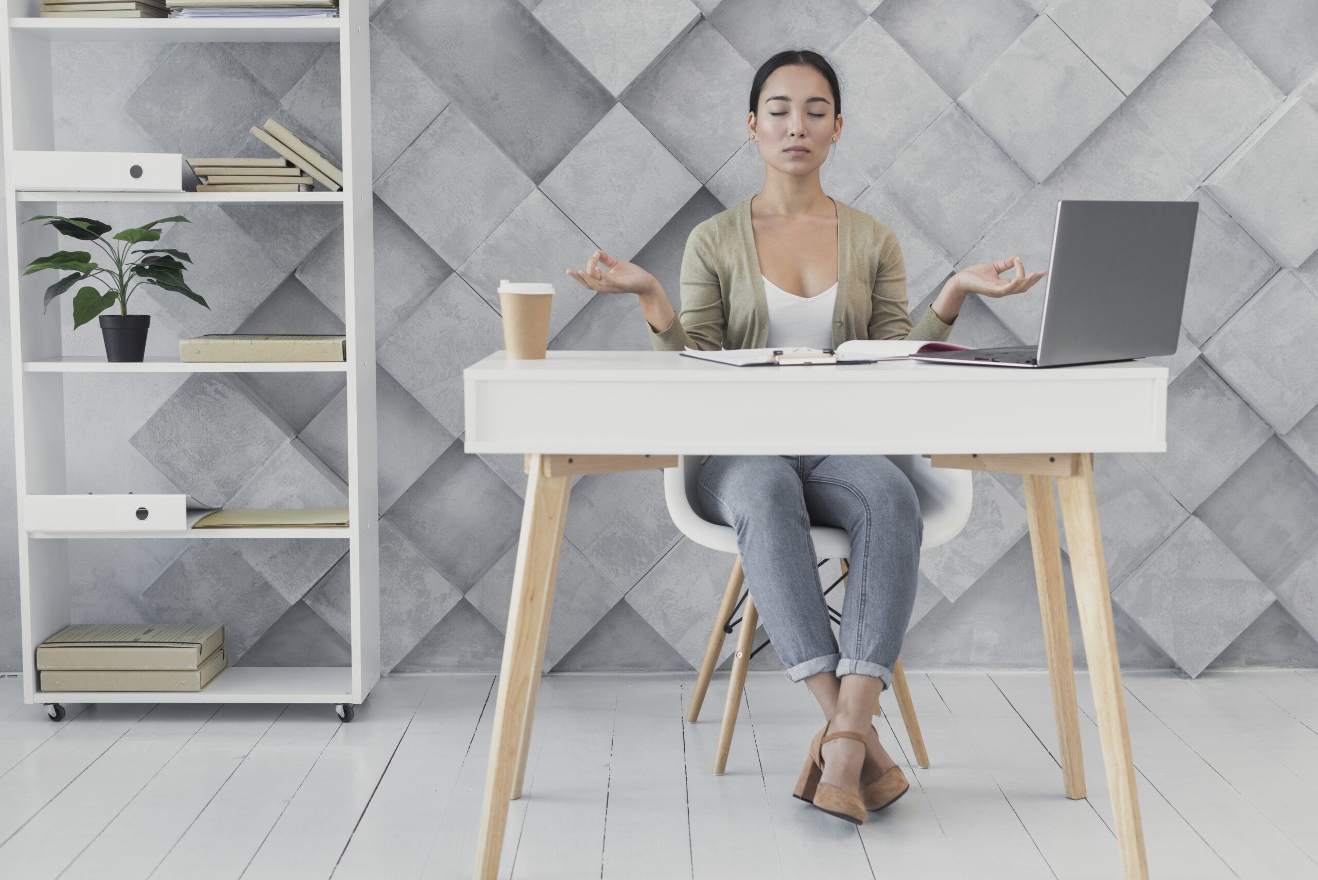 Woman meditating at her desk at Bodhiwhispers: corporate wellness packages and team building events in Brussels.