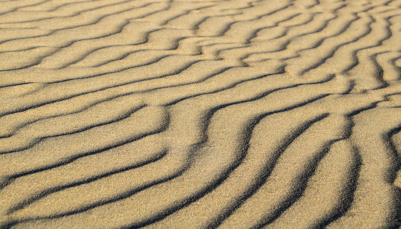 Abstract sand ripple patterns representing somatic empathy and resonance in shiatsu practice.