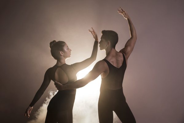 Two dancers in a graceful, energetic pose with dramatic lighting, representing the Dance of Qi and the interplay of Yin and Yang Qiao Mai.